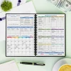 A5 Arrow-Style Budget Planner in black with modern financial icons on the cover, shown open to a monthly budget layout with tracking tables.