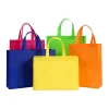 An assortment of vibrant non-woven promotional bags in yellow, blue, pink, green, and orange on a white background.