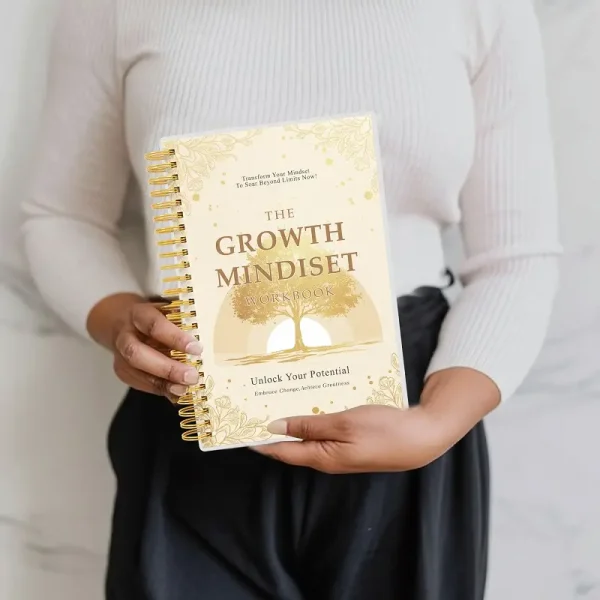 A person holding The Growth Mindset Workbook, demonstrating its portable A5 size and professional design.